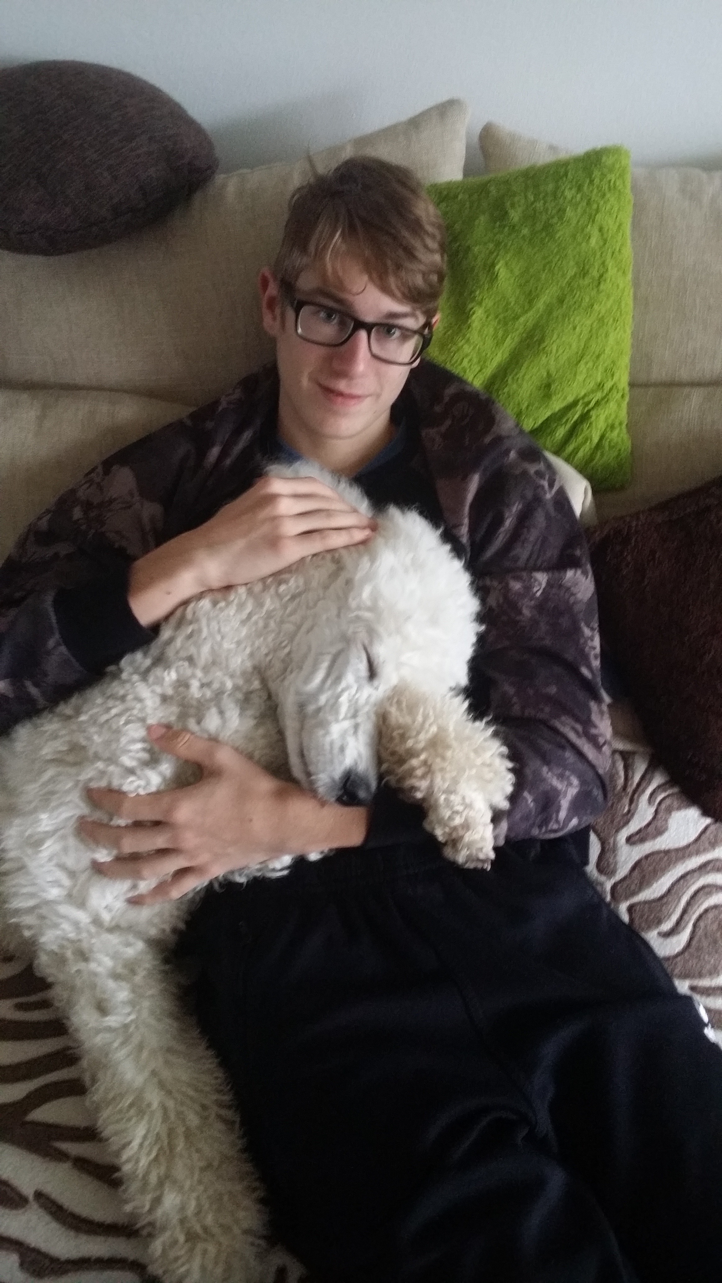 Yannick in jungen Jahren mit einem Hund auf dem Sofa