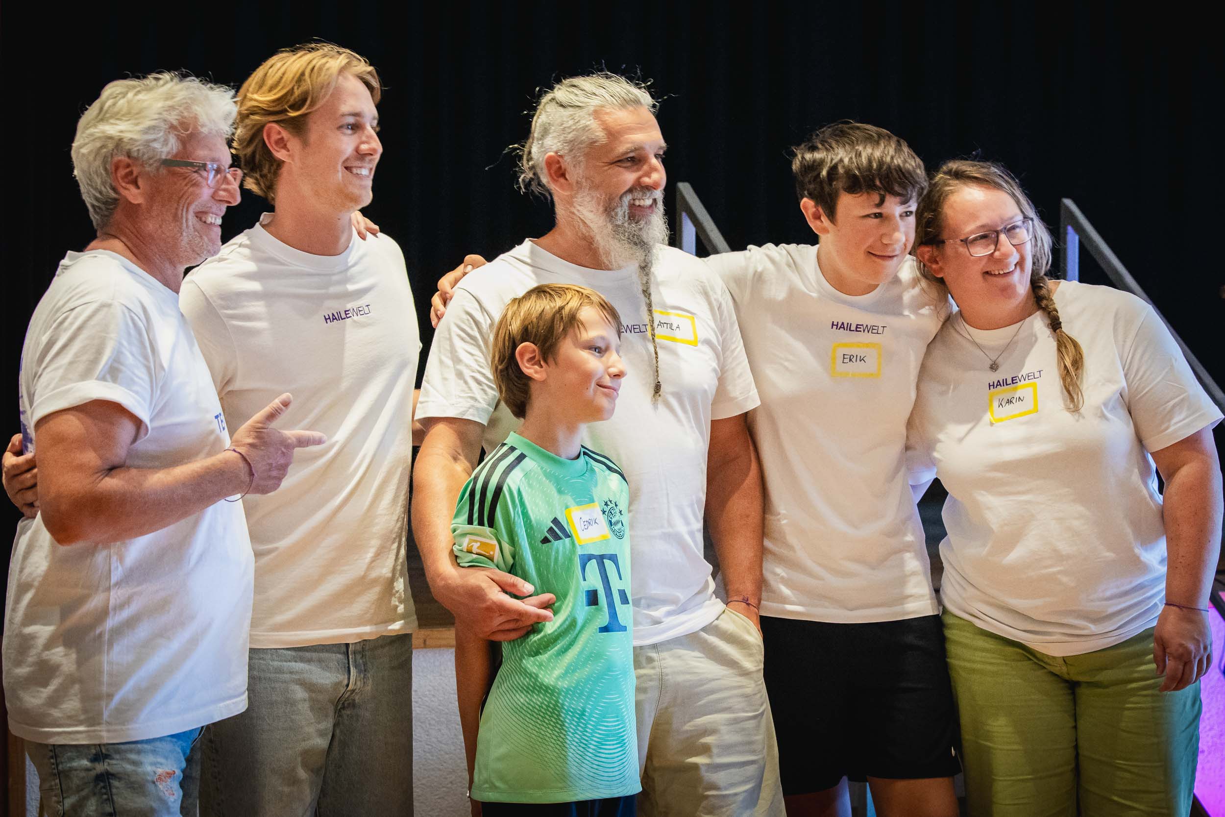 Familien und Begleiter stehen Arm in Arm zusammen und lachen